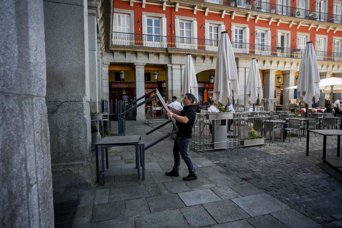 Un camarero recoge la terraza del restaurante en el que trabaja.