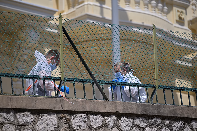 Investigators examine the scene at the residential building where an explosive device seriously injured three people a day earlier in Monaco, 30 June, 2026