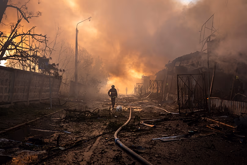 Firefighters try to put out a fire at a city marketplace following a Russian missile and drone attack in Kyiv, 15 June, 2026