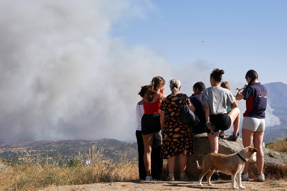 Un grupo de personas observa el humo del Incendio de Burgohondo (Ávila) desde el puerto de Navalmoral. (EFE / Raúl Sanchidrián)