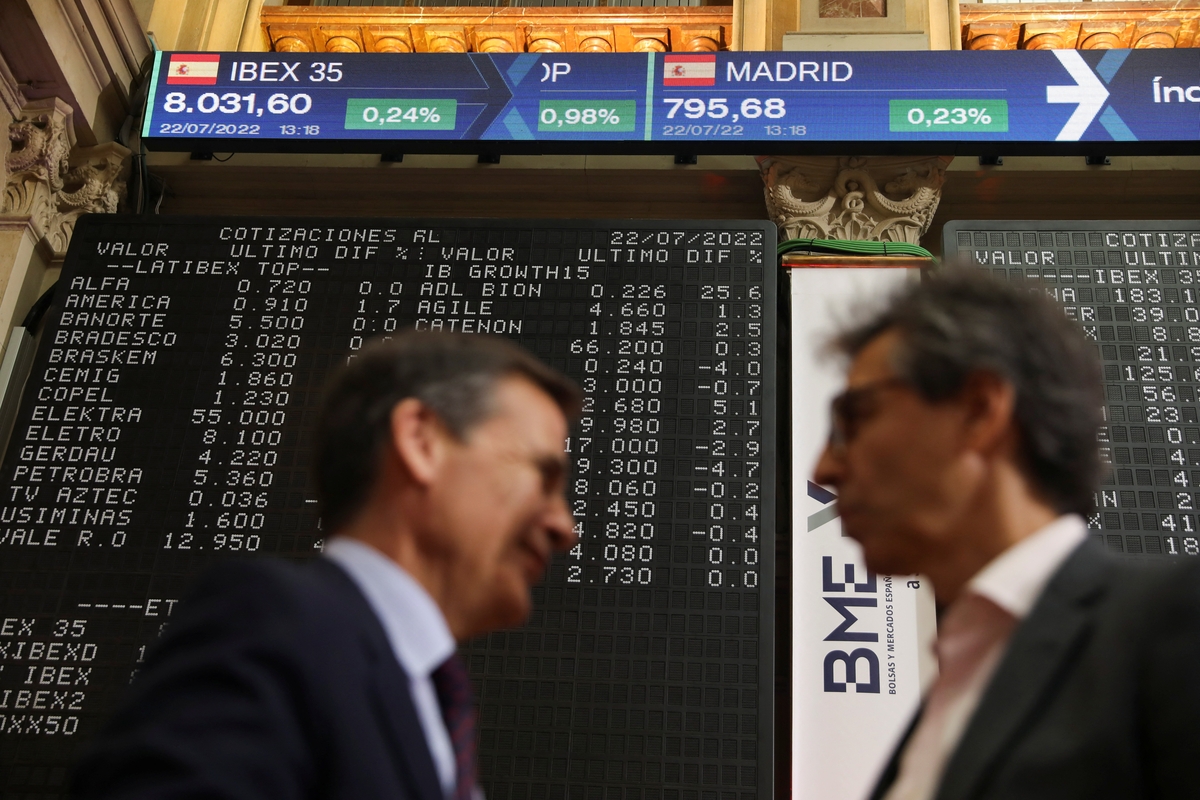 Dos hombres junto a los paneles electrónicos que muestran el valor del IBEX 35 en la bolsa de Madrid. REUTERS/Isabel Infantes