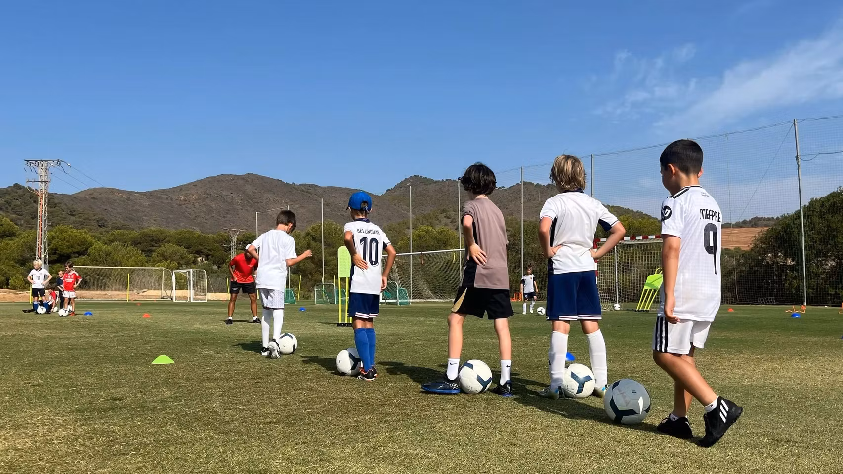 Un grupo de niños haciendo un ejercicio técnico con el balón en la academia de fútbol de La Manga Club.