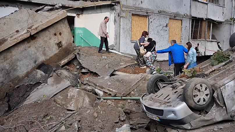 Local residents walk amid debris following a Russian missile attack in Kyiv, 6 July, 2026