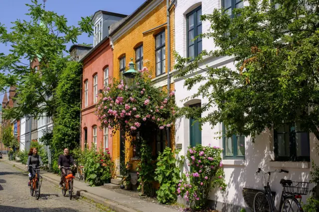 Dos personas en bicicleta por una calle de Copenhague, ciudad que encabezó el Índice Global de Habitabilidad por segundo año consecutivo.