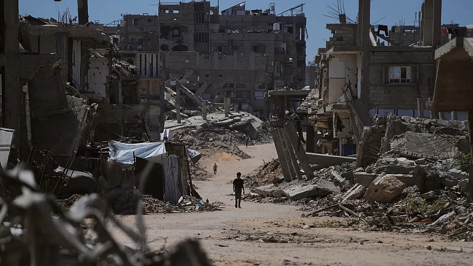 A Palestinian child walks along a street surrounded by buildings destroyed in Israeli military strikes in Khan Younis, 1 July, 2026