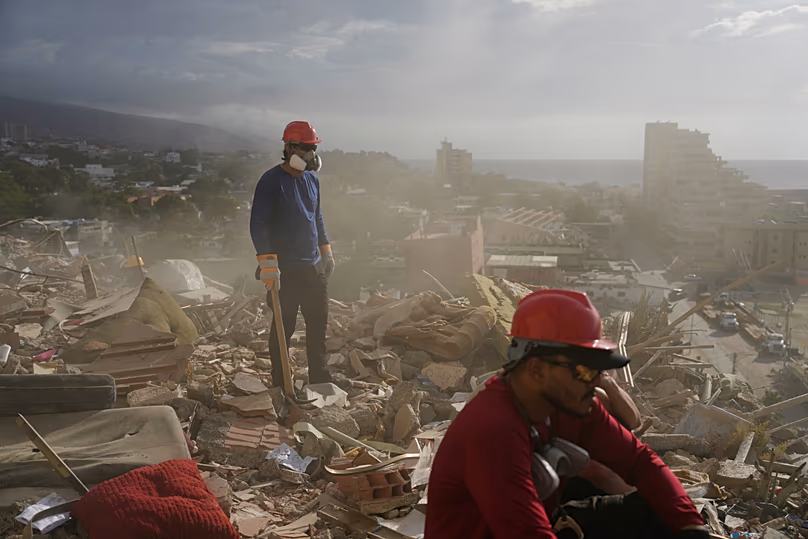 Rescue workers and volunteers search through the rubble of a building collapsed during the earthquakes in La Guaira, Venezuela