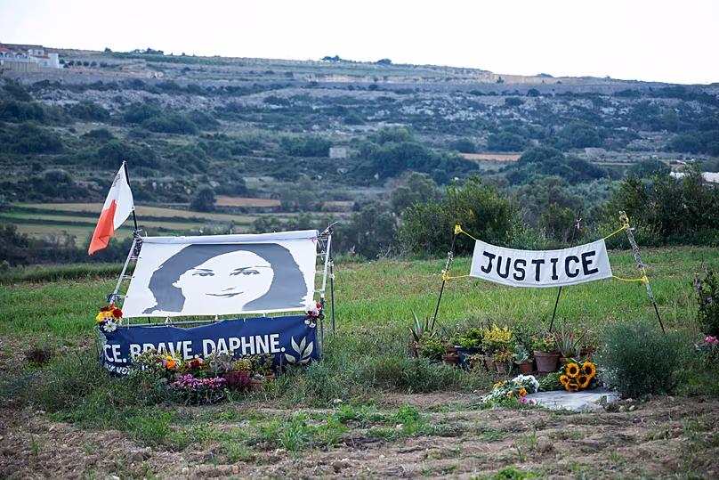 A drawing of Daphne Caruana Galizia and a banner reading 'Justice' during a silent gathering at the place where she was killed in Bidnija fields, 16 October, 2022