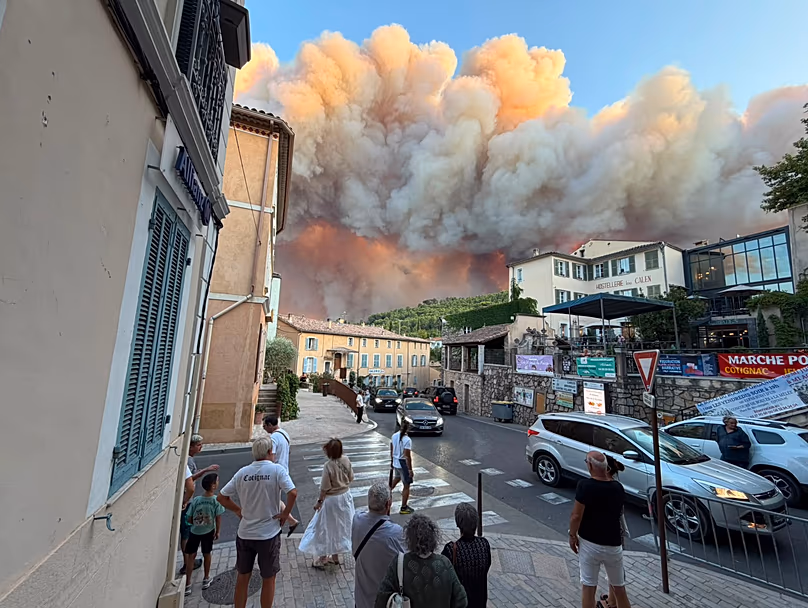 Residents look on as smoke and fire approach the village of Pontignac, in Provence, south of France, 21 July 2026