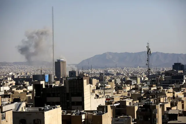 En la imagen se observa humo saliendo entre los edificios en Teherán.