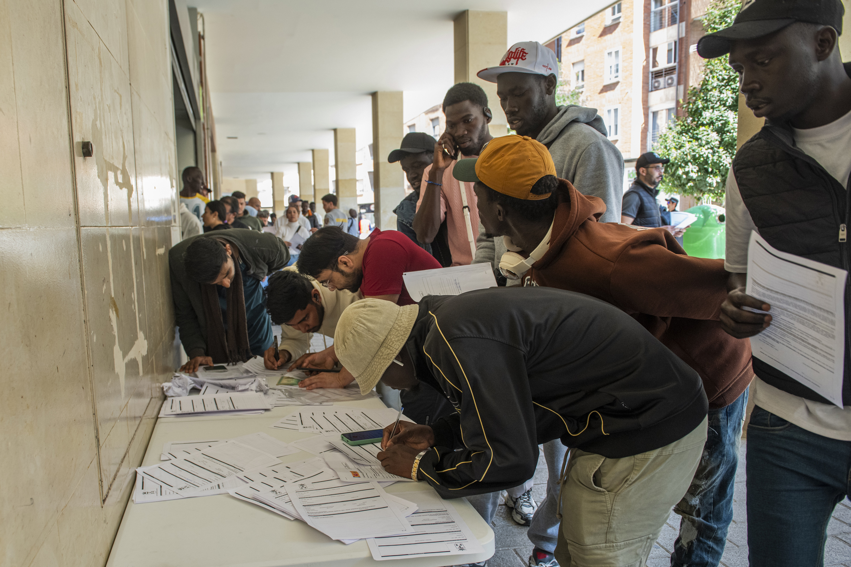 Varias personas hacen cola para la tramitación de su regularización en Albacete.