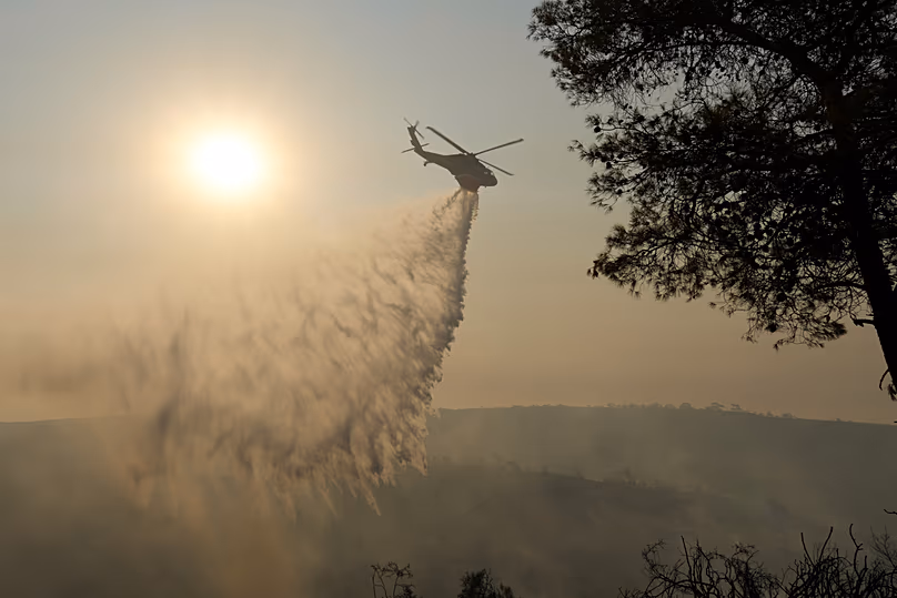 A helicopter drops water over Souni, in Cyprus, 24 July 2025