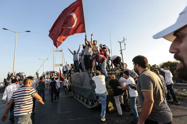 Partidarios del presidente Recep Tayyip Erdogan ondean banderas turcas mientras capturan un tanque del ejército después de que los soldados involucrados en el intento de golpe de Estado se rindieran en el puente del Bósforo de Estambul.