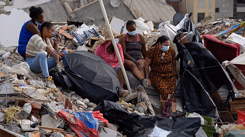 People left displaced sitting on the rubble following the earthquakes in June