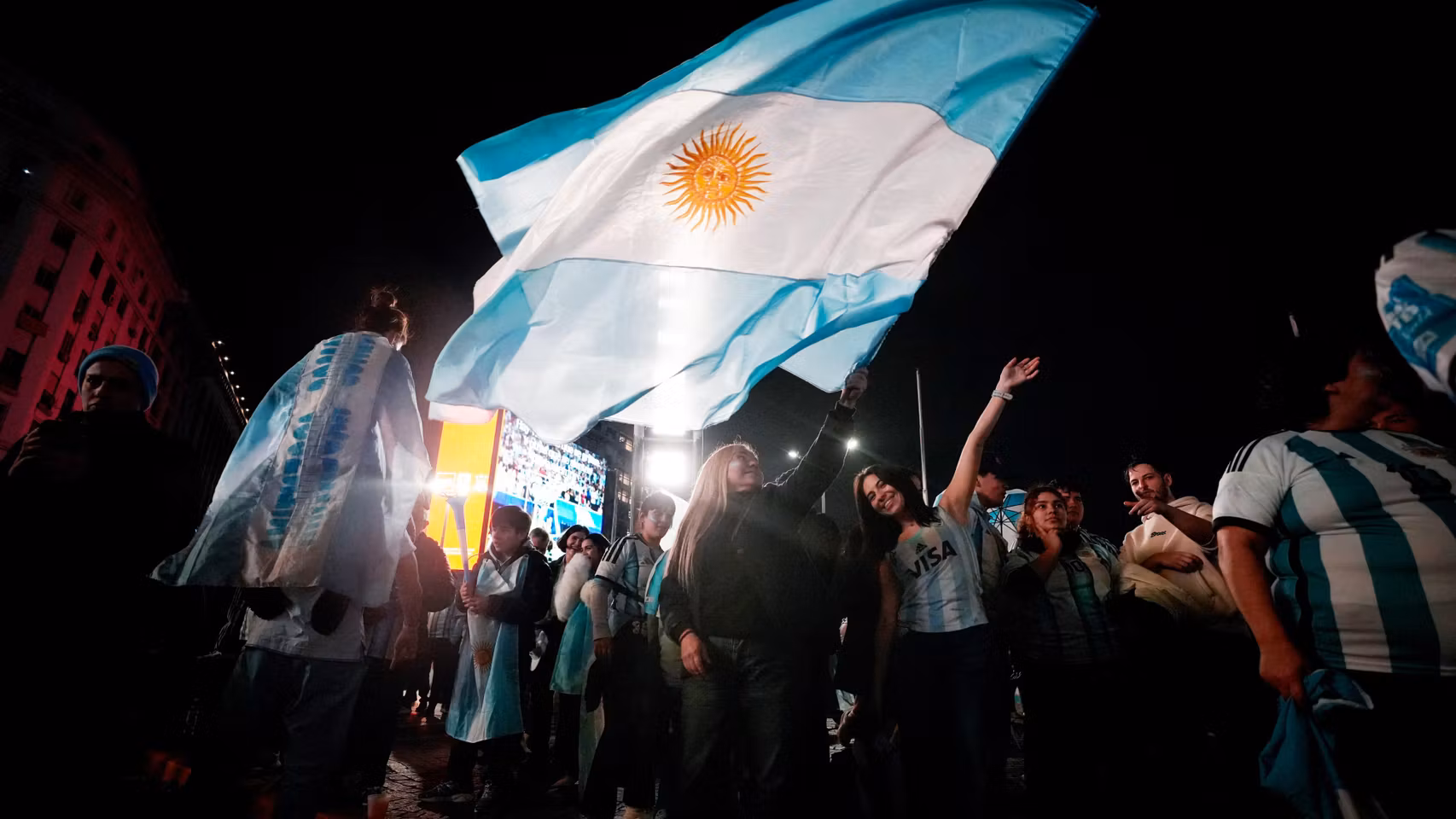Aficionados argentinos celebran con banderas la clasificación de Argentina para la final del Mundial.