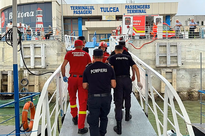 Rescuers and paramedics walking at a docking area in Tulcea, Romania, after an LPG tanker ship sailing towards a Ukrainian port caught fire, Tuesday, July 21, 2026, 