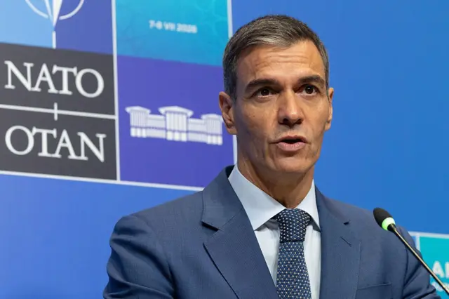 Pedro Sánchez, presidente del gobierno español, habla durante la cumbre de la OTAN en Turquía. Viste traje azul con corbata azul y camisa clara.