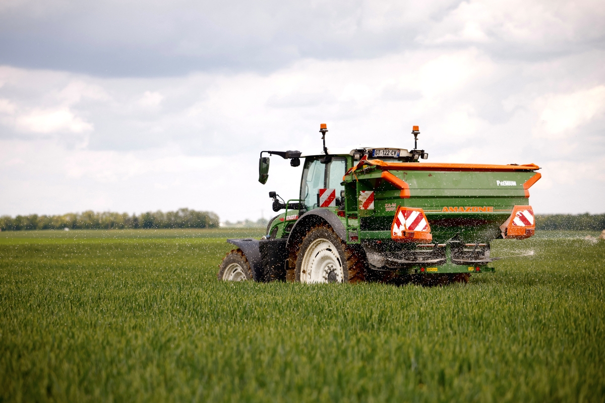Un cerealista francés conduce su tractor con un disco giratorio que esparce gránulos blancos de fertilizante nitrogenado en un campo de trigo en Larchant, Francia, el 7 de mayo de 2026. REUTERS/Alice Sacco