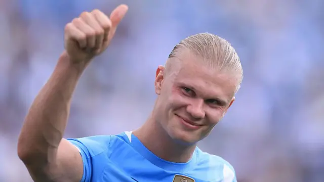 Erling Haaland saluda a la gente y sonríe.
