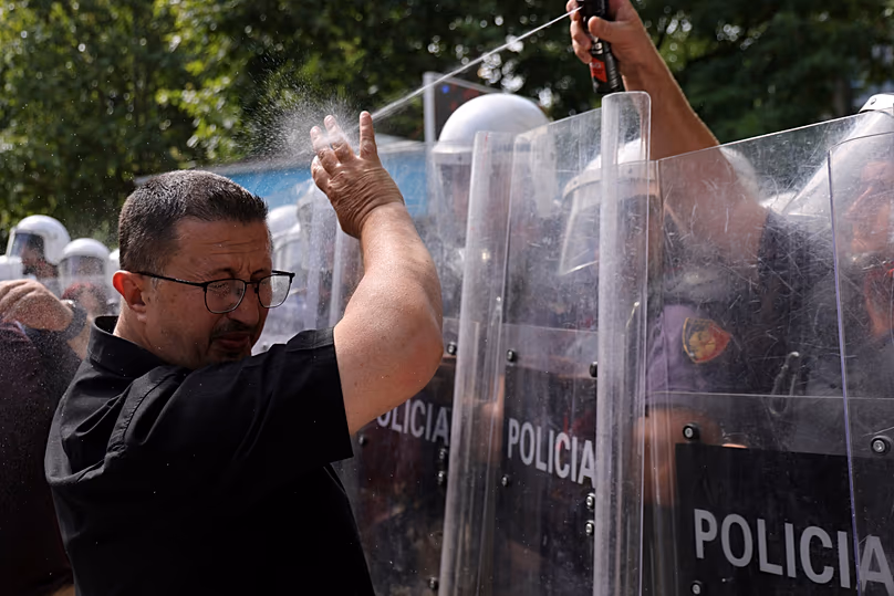 A riot police officer uses pepper spray against a protester during clashes at an anti-government rally in Tirana, 2 July, 2026