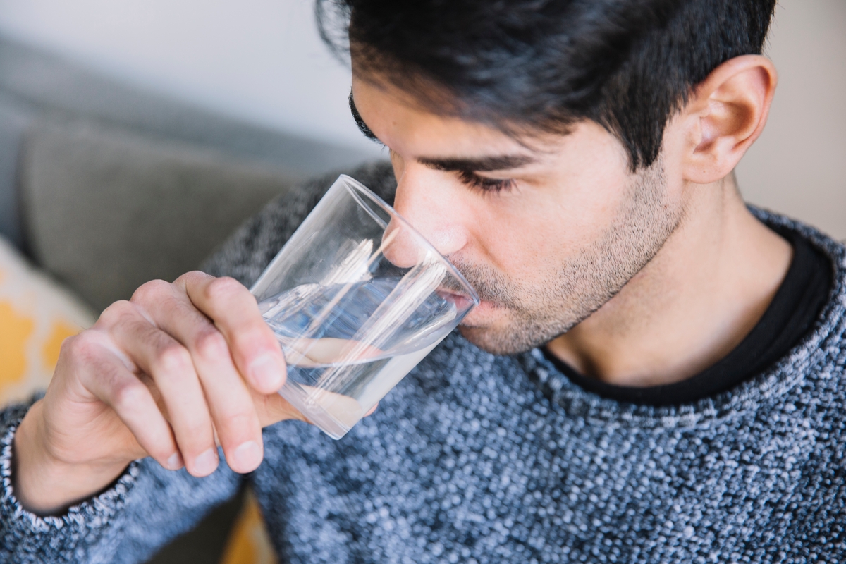 Un hombre bebe un vaso de agua (Magnific)
