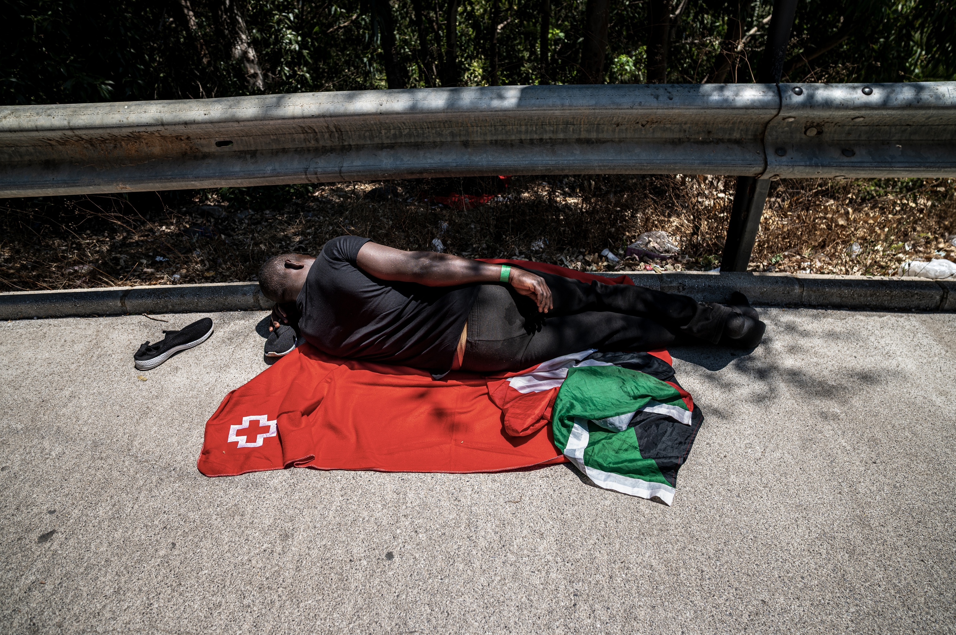 Un joven migrante duerme fuera del CETI de Ceuta esperando turno para ingresar en el centro.