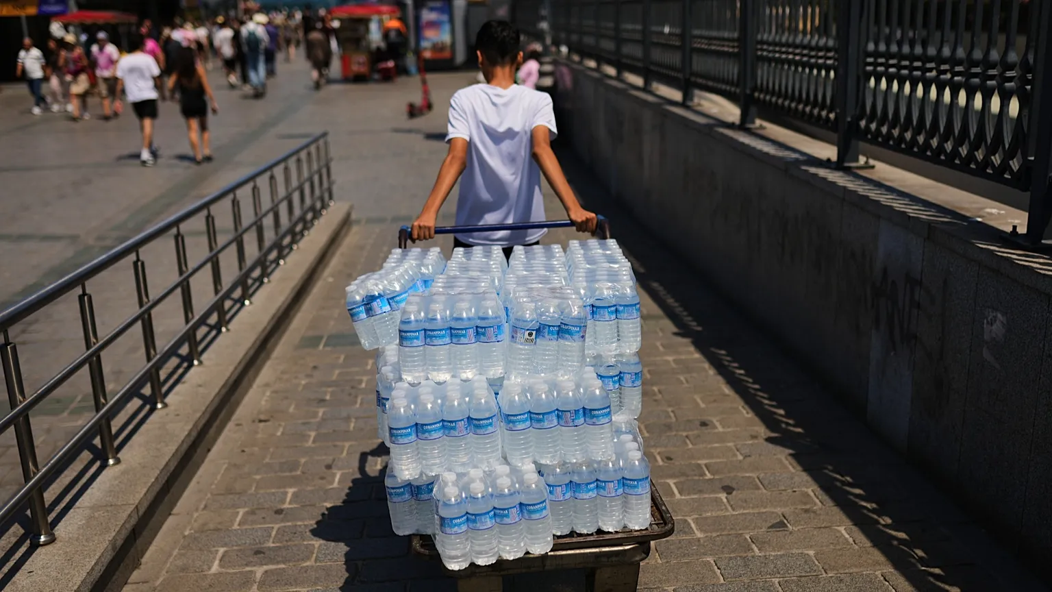 A man delivers plastic bottles of water during a hot day in Istanbul, Turkey, Saturday, June 20, 2026. (AP Photo/Francisco Seco)