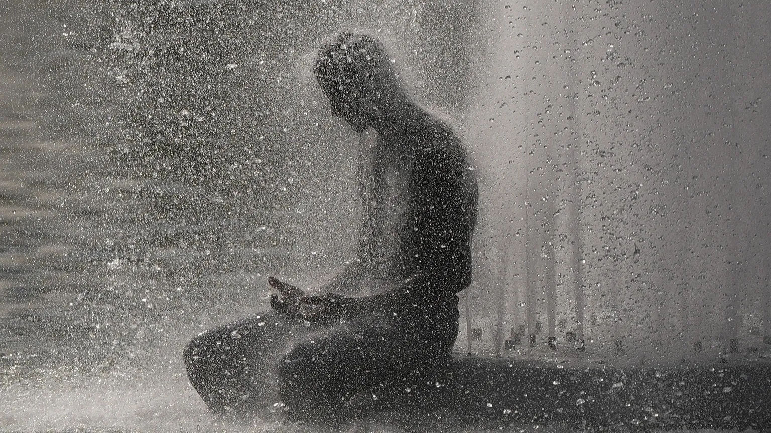 A person cools off at Trocadero fountain near the Eiffel Tower during a heat wave in Paris, 24 June, 2026