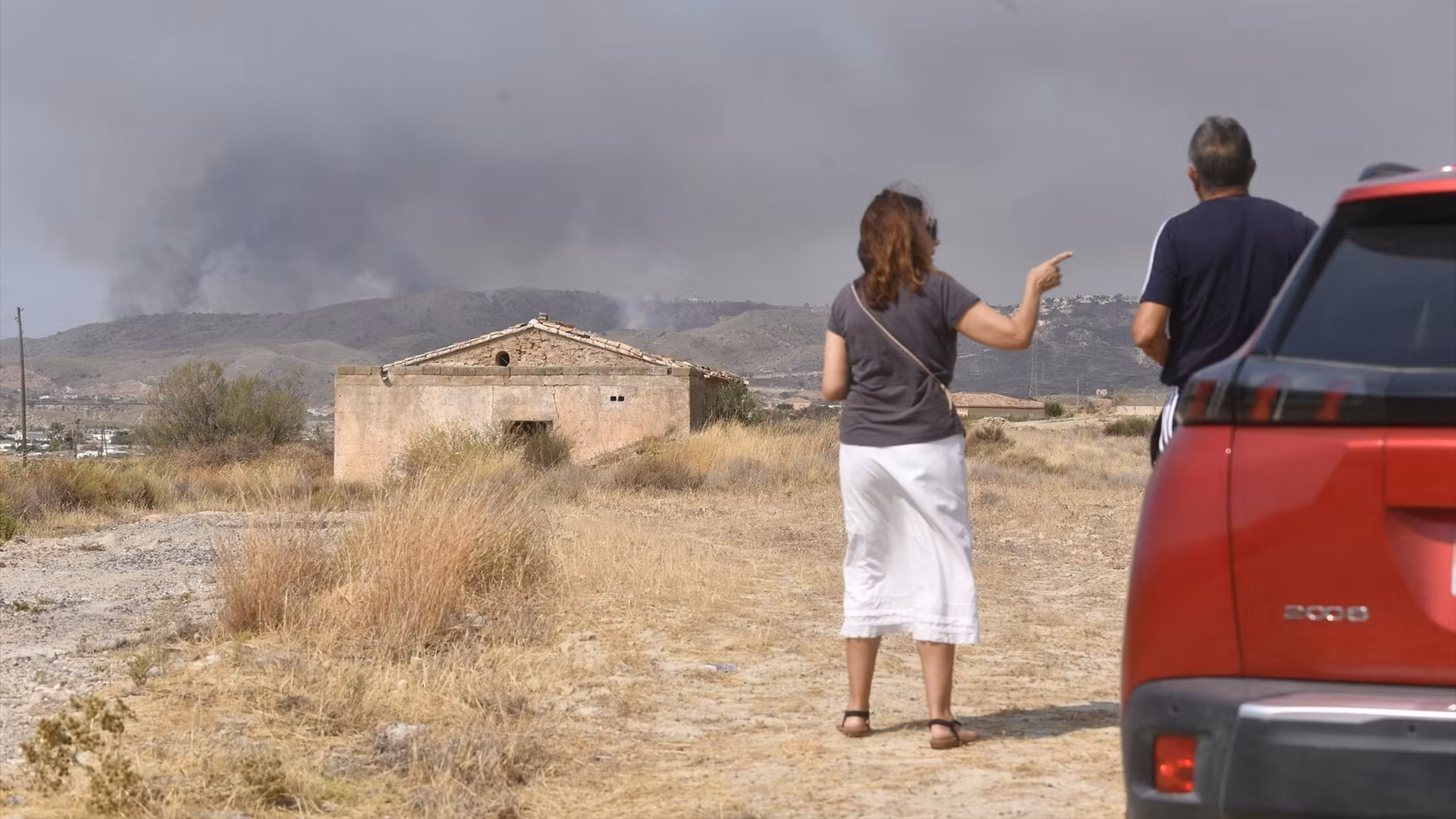 Dos personas observan el avance del incendio.