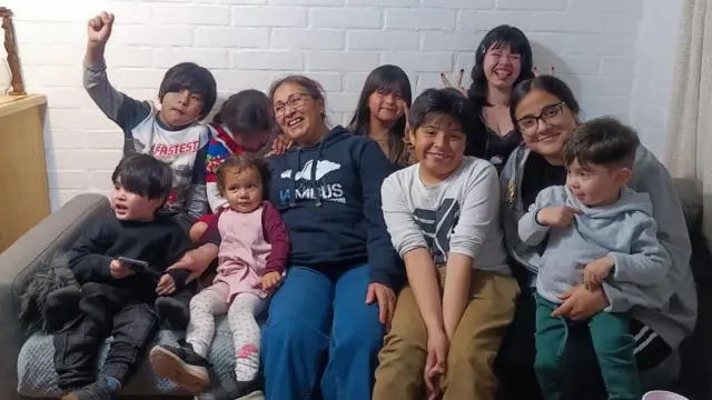 Elisabeth Osorio en un sillón con parte de su familia.
