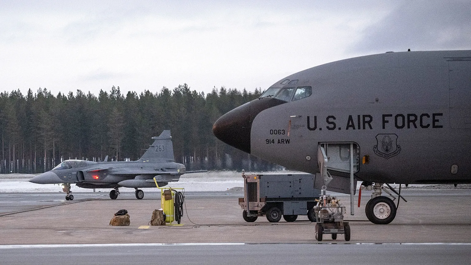 A fighter jet, left, passes a US KC-135 Stratotanker, a US military tanker aircraft, during a military exercise near Luleå, Sweden, March 4, 2024