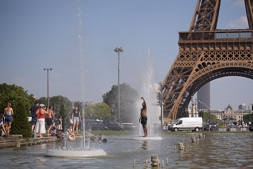 People cool off at Trocadero fountain near the Eiffel Tower during a heat wave in Paris, Wednesday, June 24, 2026.